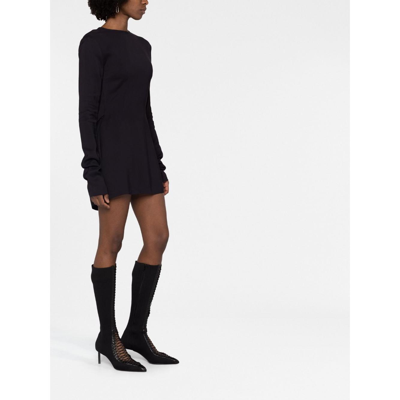 Alt Tag: 032c Kicked Back black dress with cut-out detailing, round neck, and long sleeves; model wears size 36, styled with high boots.