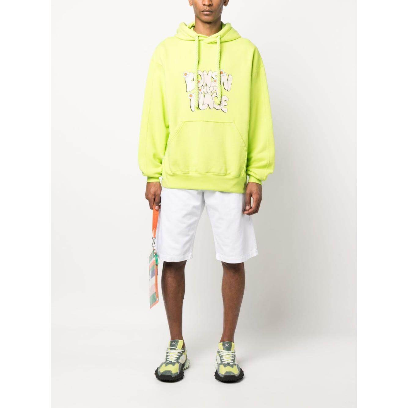 Model wearing neon green Bonsai slogan-print hoodie with drawstring hood, front pouch pocket, ribbed cuffs, and hem, paired with white shorts.