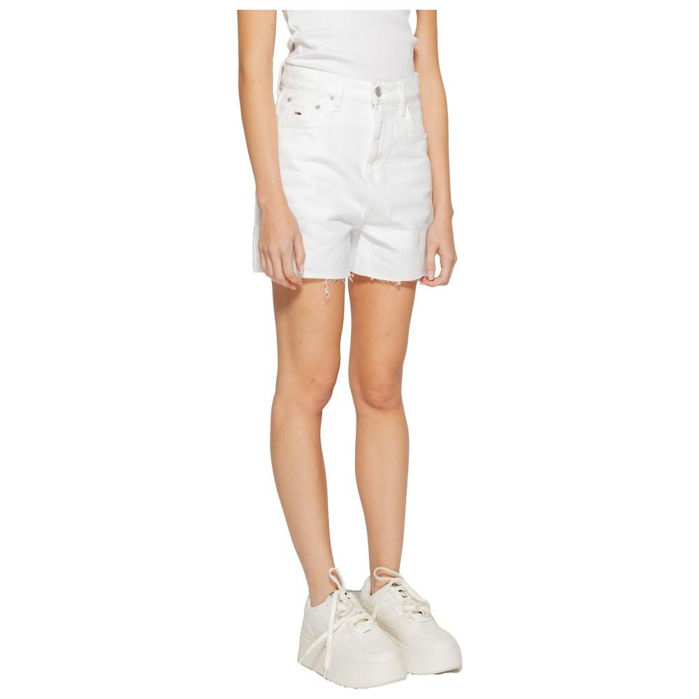 Woman wearing Tommy Hilfiger white recycled cotton shorts, spring/summer collection, featuring a casual style with sneakers.