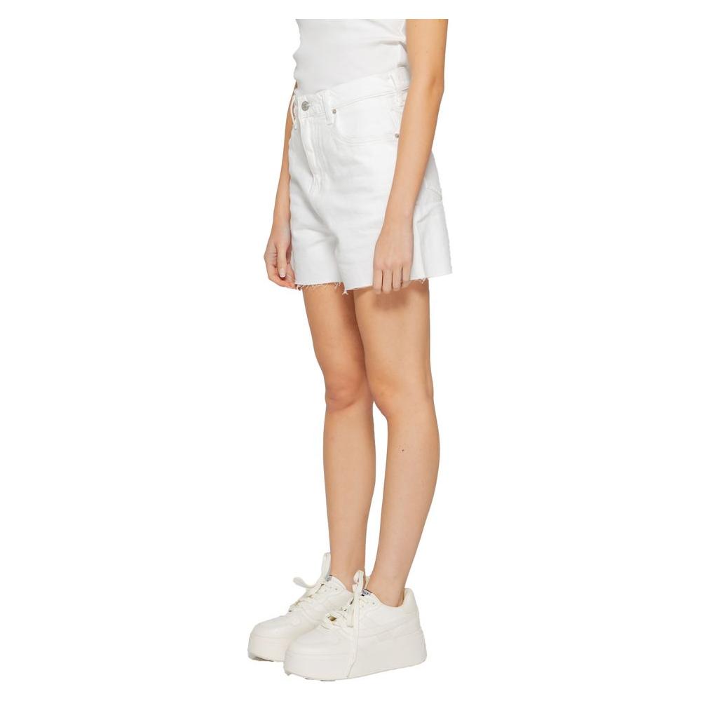 Woman wearing Tommy Hilfiger white recycled cotton shorts, Spring/Summer collection, eco-friendly fashion.