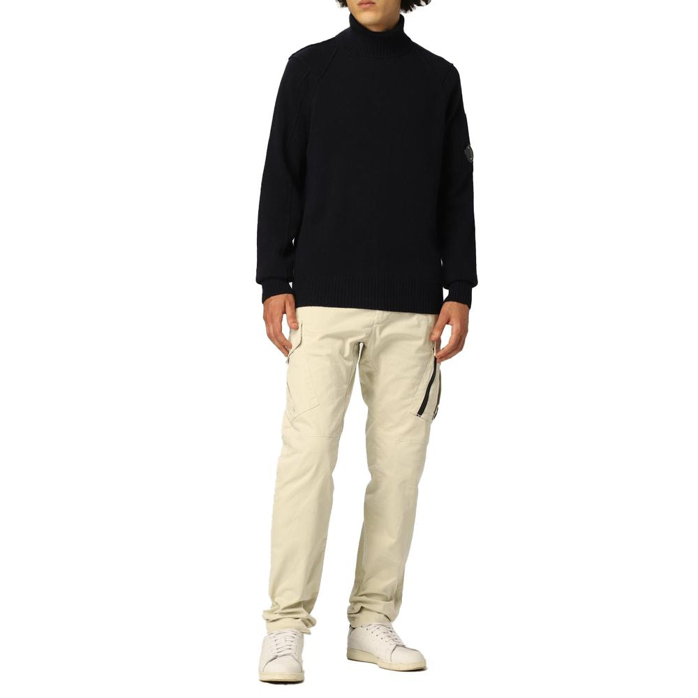 Model wearing C.P. Company Blue Wool Sweater with ribbed turtleneck, cuffs, and hem, featuring a logo plaque on the shoulder.