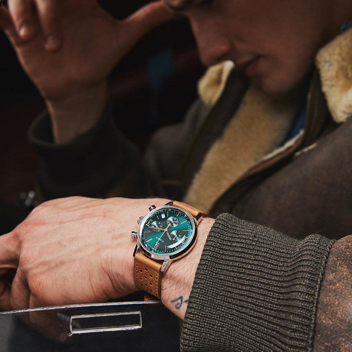 Close-up of person wearing TIMEX WATCHES Mod. TW2W10100A with a brown leather strap, showcasing the watch's detailed green dial design.