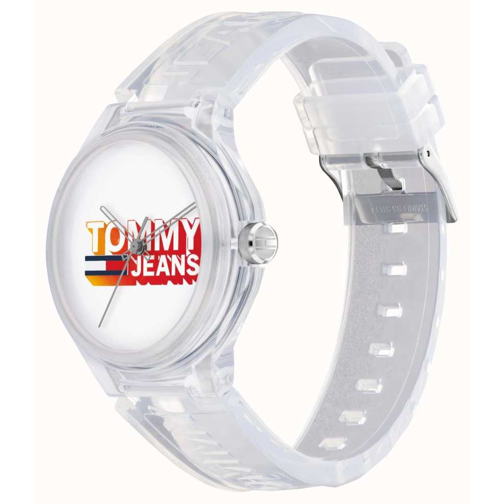 Transparent watch with TOMMY JEANS logo on dial, featuring quartz analog movement and unisex design in official packaging.
