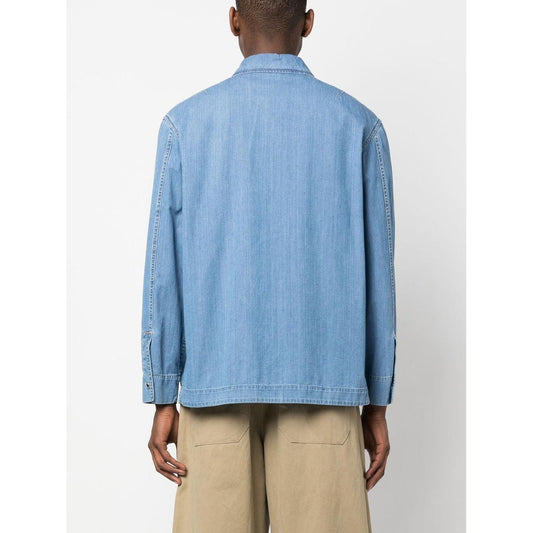 Back view of model wearing Lanvin zip-up denim shirt in light blue with long sleeves and classic collar, paired with beige pants.