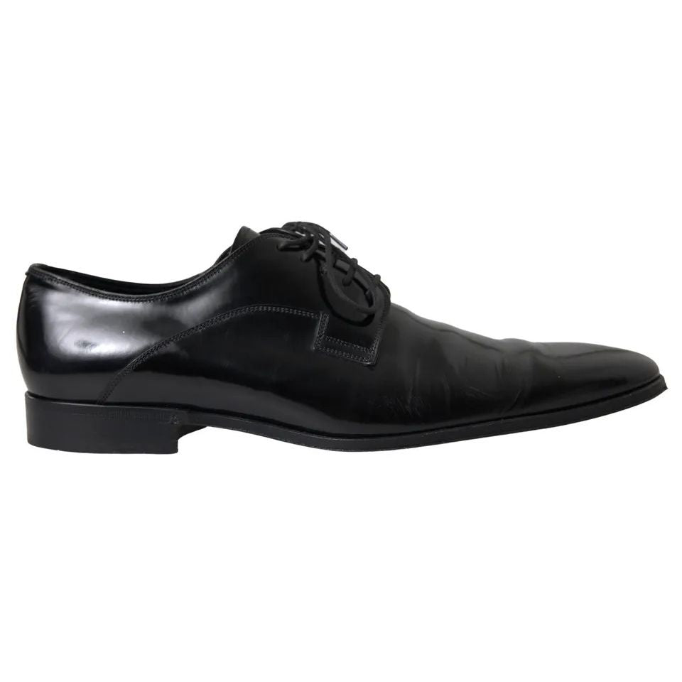 Dolce & Gabbana Black Polished Leather Formal Dress Shoes in polished leather, revealing logo details, slight wear, exclusive craftsmanship, side view.