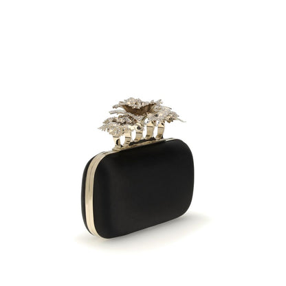 Alexander McQueen Black Silk Clutch Bag with crystal carnation knuckle handle and gold chain on a white background, AW25 collection.