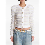 Model wearing Balmain Long-sleeved tweed-effect knit cardigan with white button fastening and pinched shoulders, paired with jeans.