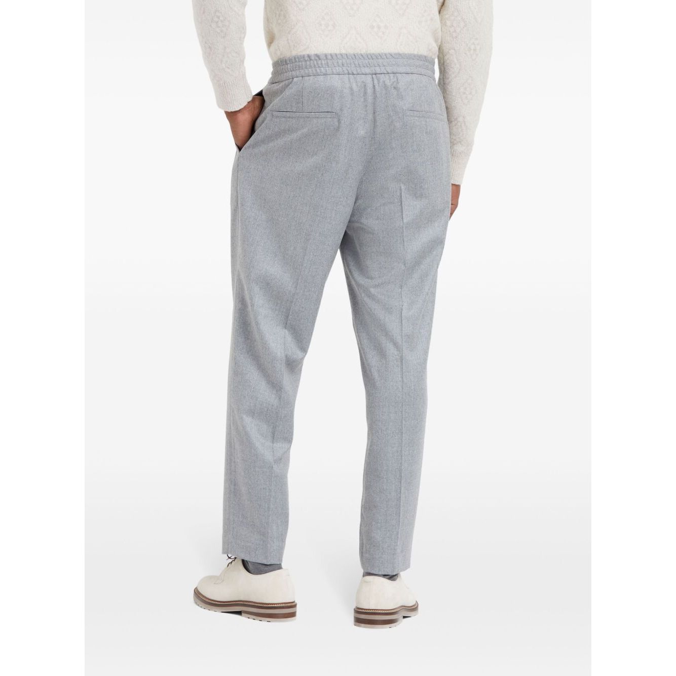Back view of Brunello Cucinelli Drawstring trousers in beluga grey virgin wool with tapered leg, elasticated waistband, and jetted pockets.