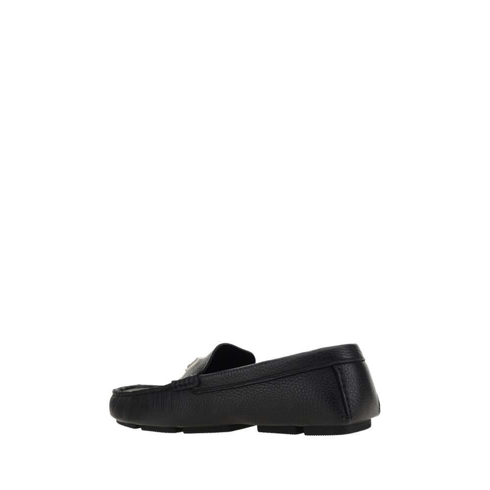 Dolce & Gabbana Black Rubber Slip-On Loafers with calfskin upper and metal monogram plaque, side view showing non-slip sole.
