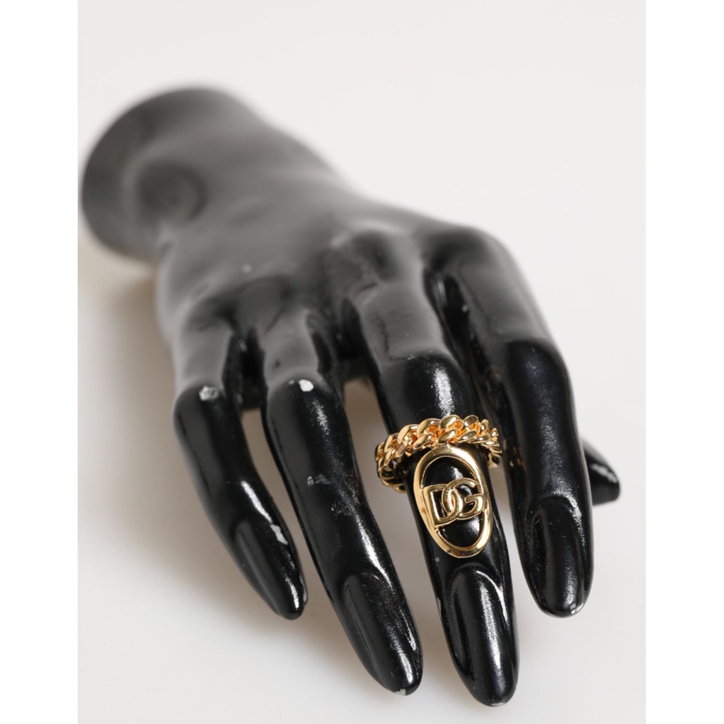Dolce & Gabbana Gold Tone Brass Oval DG Logo Chain Adjustable Ring on a black mannequin hand.