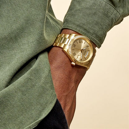 Man wearing GUESS Mod. CONNOISSEUR gold watch with 44 mm case and quartz movement, 3 ATM water resistance on wrist