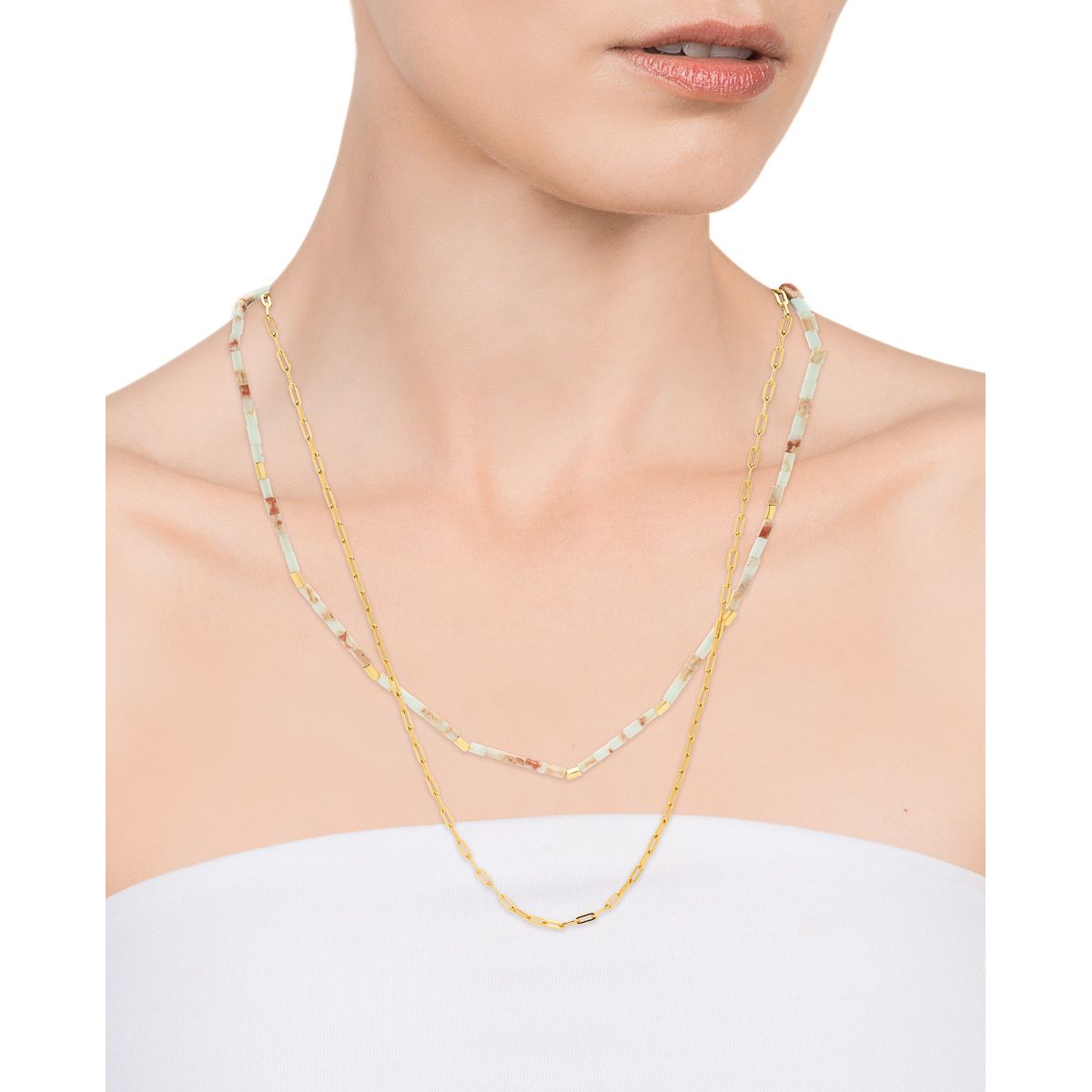 Woman wearing a gold and silver toned layered necklace with minimalist design.