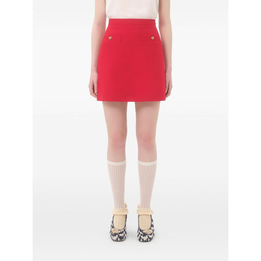 Model wearing Valentino Crepe Couture Skirt, red wool and silk skirt with heart motif faux pocket detail and side zip fastening.