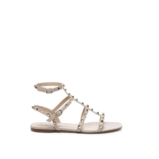 Alt Tag: Valentino Garavani Beige Calfskin Sandals with gold-tone rockstud embellishments and ankle buckle fastening, made in Italy.