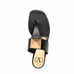 Valentino Garavani One Stud sandals in black leather with thong strap, round toe, and signature stud detail, viewed from above.